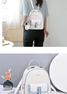 Close-up of white fashion backpack featuring light blue trim, pearl and pompom charms
