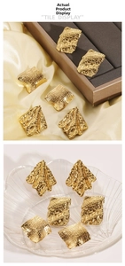 Detailed macro view of geometric gold earrings with textured hammered metal finish