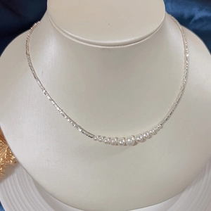 Detail view of S925 silver necklace with gradient natural freshwater pearls on a neck display