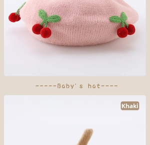 Detail of baby knitted beret with 3D plush cherry decoration in pink and khaki