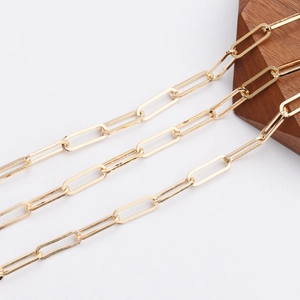 Minimalist 18K gold plated paperclip chain necklace on a premium dark wood display block