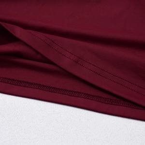 Vue macro du tissu tricoté bordeaux montrant les détails de l'ourlet à double aiguille