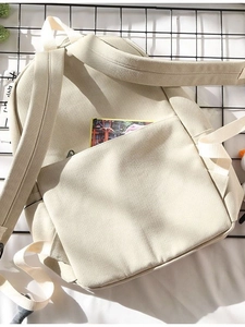 Minimalist beige canvas backpack for travel and school showing rear shoulder straps