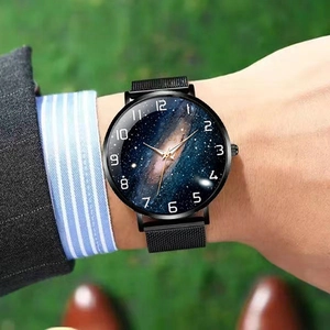 Macro shot of men's watch featuring a starry sky dial and black mesh stainless steel strap
