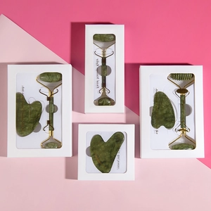 Detailed view of natural green jade roller and gua sha sets in elegant gift boxes