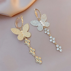 Detailed macro view of the front and back of luxury gold butterfly drop earrings with pearls