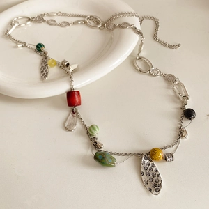 Detail of vintage bohemian necklace with colorful ceramic beads and silver floral pendant