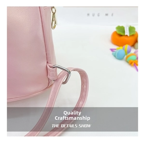 Close-up of metal D-ring buckle and fine stitching on pink leather shell backpack