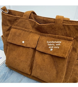 Detailed macro view of brown corduroy tote bag showing textured stripes and front pockets