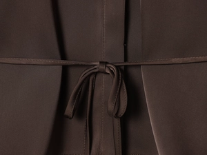 Vue détaillée du tissu satiné marron foncé avec un nœud décoratif et texture soyeuse