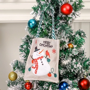 Linen Christmas gift bag featuring a snowman pattern hanging on a decorated tree