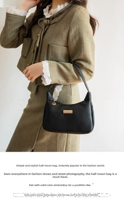 Close-up of black lychee grain leather crescent bag with golden metal buckle and leaf zipper