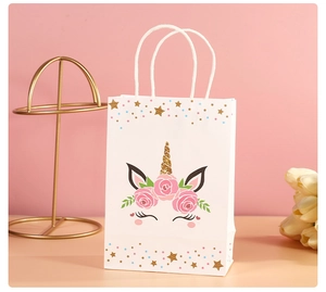 Detailed view of white unicorn gift bag with golden horn and floral patterns