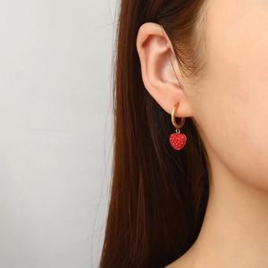 18K gold plated hoop earrings with red heart crystal pendant worn by a female model