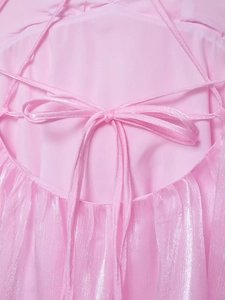 Detail von rosa perlmuttfarbenem Kleiderstoff mit weicher Schleife und feiner Faltung