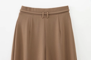 Detailed close-up of high waist textured brown wide-leg trousers with belt loops
