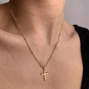 Minimalist 18K gold plated stainless steel cross necklace worn by model for elegant look