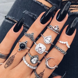 Gros plan d'un ensemble de bagues bohèmes en argent avec gemmes et motifs couronnes