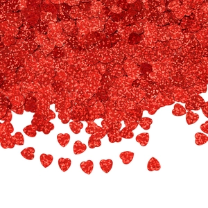 Macro view of scattered red heart-shaped glitter sequins made of PVC for party decor