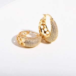 Close-up of gold-plated C-shape hoop earrings with micro-set zircon and round hollow details