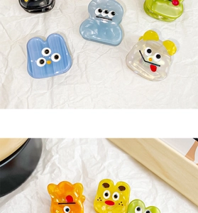 Close-up of colorful mini acetate hair claws featuring fun cartoon facial expressions