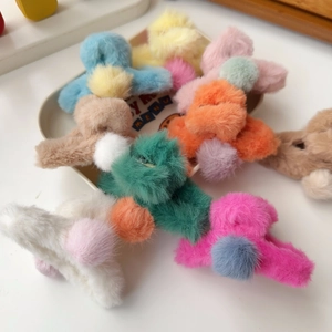 Multiple colorful plush hair claws with fluffy faux fur texture in a heart-shaped tray