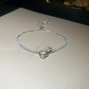 Macro detail of silver knot bracelet with heart zircon and adjustable sliding clasp