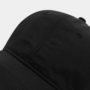 Macro detail of breathable embroidered eyelets and multi-row stitching on black baseball cap