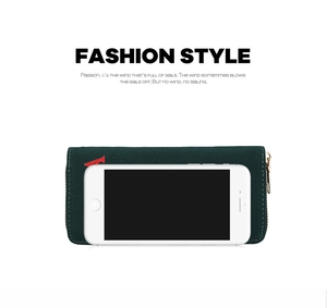 Detail view of long green canvas wallet with red letter A next to a smartphone