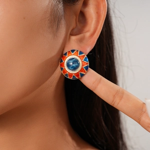 Close-up of geometric floral resin stud earrings with orange and blue enamel work