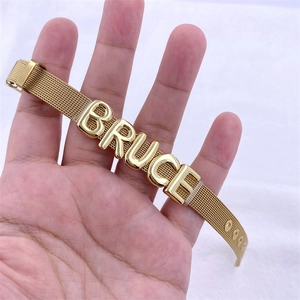 Detail of custom golden mesh bracelet with large 3D letters spelling BRUCE