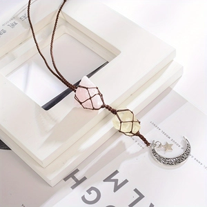 Gros plan du pendentif en cristal brut tissé avec breloques lune et étoile en argent