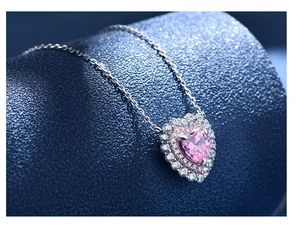 Macro view of pink heart diamond pendant with double halo stones on a silver chain