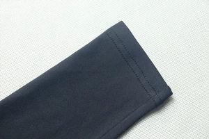 Close-up of double-needle stitching on the cuffs of a black ruched long-sleeved dress