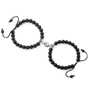Detail of magnetic silver sphere buckle connecting black lava and matte stone bracelets