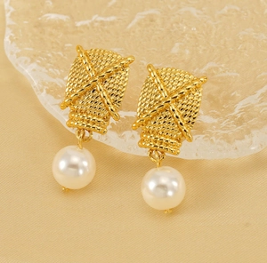 Detailed macro view of 18K gold textured square earrings with elegant pearl pendants