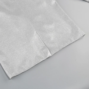 Macro view of silver sequin fabric detailing textured metallic weave of the 3-piece set
