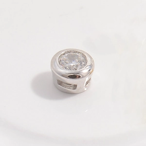 Macro shot of S925 silver cylinder bead with a round brilliant-cut white zircon inlay