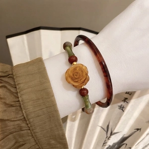 Detailed shot of retro Chinese style pearl bracelet with amber resin bangle and rose bead