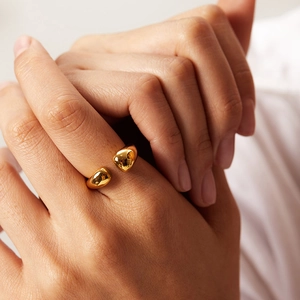 Polished gold teardrop ring on finger showing adjustable open band minimalist style