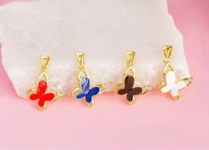 Macro detail of enamel butterfly charms with cubic zirconia on gold-plated copper base