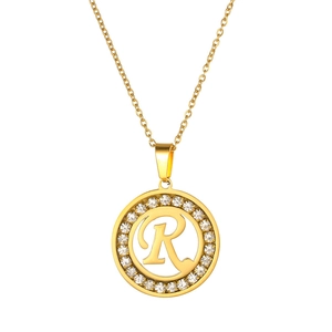 Detail of golden round necklace with crystal-paved letter R pendant and fine O-chain