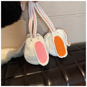 Detail of handmade knit bunny bucket bag with cute long ears and drawstring closure