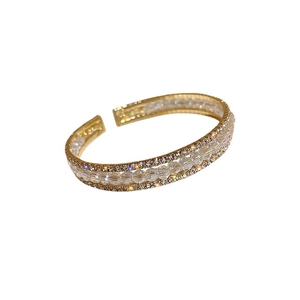 Elegant gold-plated cuff bracelet featuring white glass beads and sparkling rhinestones