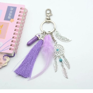 Macro shot of purple dreamcatcher keychain with tassels, crystal and silver leaf charms