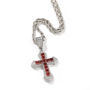 Detailed view of silver cross pendant with red square-cut zircons and pavé white stones
