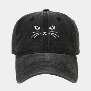 Close-up of white cat face embroidery on vintage washed black cotton baseball cap