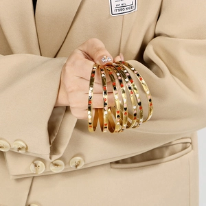 Detail of 18K gold plated multi-layer bangles with colorful heart enamel drip pattern