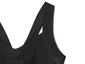 Close-up of black bodycon dress featuring wide shoulder straps and a deep V-neckline
