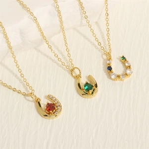 Detailed view of U-shaped horseshoe necklaces with colorful zircon stones on gold chains